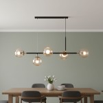Lampa wisząca Dansa 5-punktowa w kolorze czarnym i złotym, z pięcioma przezroczystymi kloszami, zawieszona na długim, prostokątnym stelażu. Zainstalowana nad drewnianym stołem w jadalni, na jednolitym, zielonym tle.