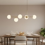 Lampa wisząca Dansa 5xE14 w kolorze złotym i białym, z pięcioma okrągłymi kloszami, zawieszona nad drewnianym stołem w jadalni. Tło w neutralnym, jasnym odcieniu, z widoczną roślinnością i zastawą stołową.