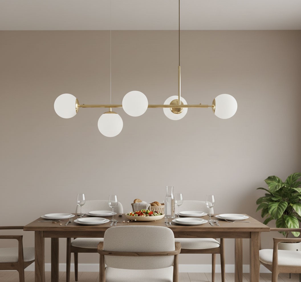 Lampa wisząca Dansa 5xE14 w kolorze złotym i białym, z pięcioma okrągłymi kloszami, zawieszona nad drewnianym stołem. Klosze wykonane z matowego szkła, lampa ma minimalistyczny design, idealna do nowoczesnych wnętrz.