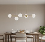 Lampa wisząca Dansa 5xE14 w kolorze złotym i białym, z pięcioma okrągłymi kloszami, zawieszona nad drewnianym stołem. Klosze wykonane z matowego szkła, lampa ma minimalistyczny design, idealna do nowoczesnych wnętrz.