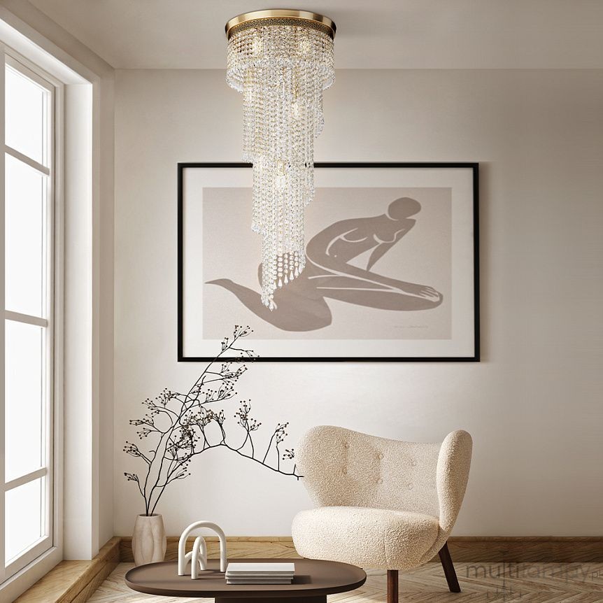 Lampa sufitowa Cascade 12-punktowa DIA522-CL-12-G z wiszącymi kryształkami, złotym stelażem, w aranżacji wnętrza. Produkt zawieszony w centralnej części pomieszczenia, w otoczeniu jasnych ścian oraz minimalistycznych mebli.