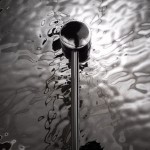 Mare kinkiet 1-punktowy chrom MOD305WL-01CH z okrągłą, chromowaną podstawą i prostą, metalową rurką. Ujęcie z góry na tle falującej, lustrzanej powierzchni. Kinkiet ma minimalistyczny design, idealny do nowoczesnych wnętrz.