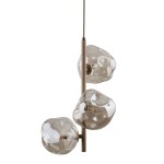 Lava Sabia lampa wisząca w kolorze beżowym z trzema szklanymi kloszami o organicznych kształtach, zawieszona na cienkim pręcie. Klosze lekko przezroczyste, eksponujące źródła światła. Ujęcie frontalne, produkt w pozycji wiszącej.