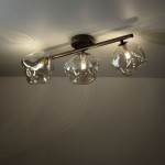 Brązowa lampa sufitowa Lava Brown z trzema kloszami G9. Klosze o organicznym kształcie wykonane z przezroczystego szkła, zamontowane na metalowej oprawie. Ujęcie z dołu, pokazujące szczegóły kloszy i ich rozmieszczenie.
