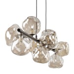 Brązowa lampa wisząca Lava Brown z dziewięcioma kloszami G9, z przezroczystego szkła o organicznych kształtach, zawieszona na czarnym metalowym ramieniu. Klasyczne i nowoczesne elementy łączą się, tworząc efektowną kompozycję.