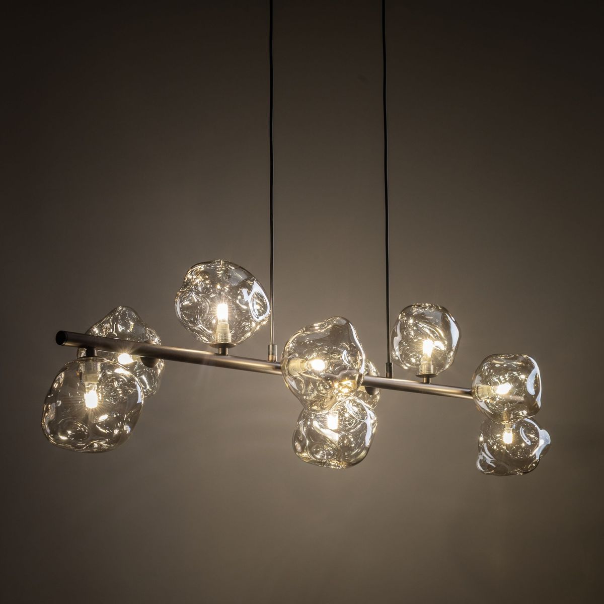 Lava Brown lampa wisząca z 9 źródłami światła G9, brązowa metalowa konstrukcja z przezroczystymi, organicznymi kloszami. Lampa zawieszona na czarnych przewodach, w nowoczesnym stylu, idealna do aranżacji wnętrz.