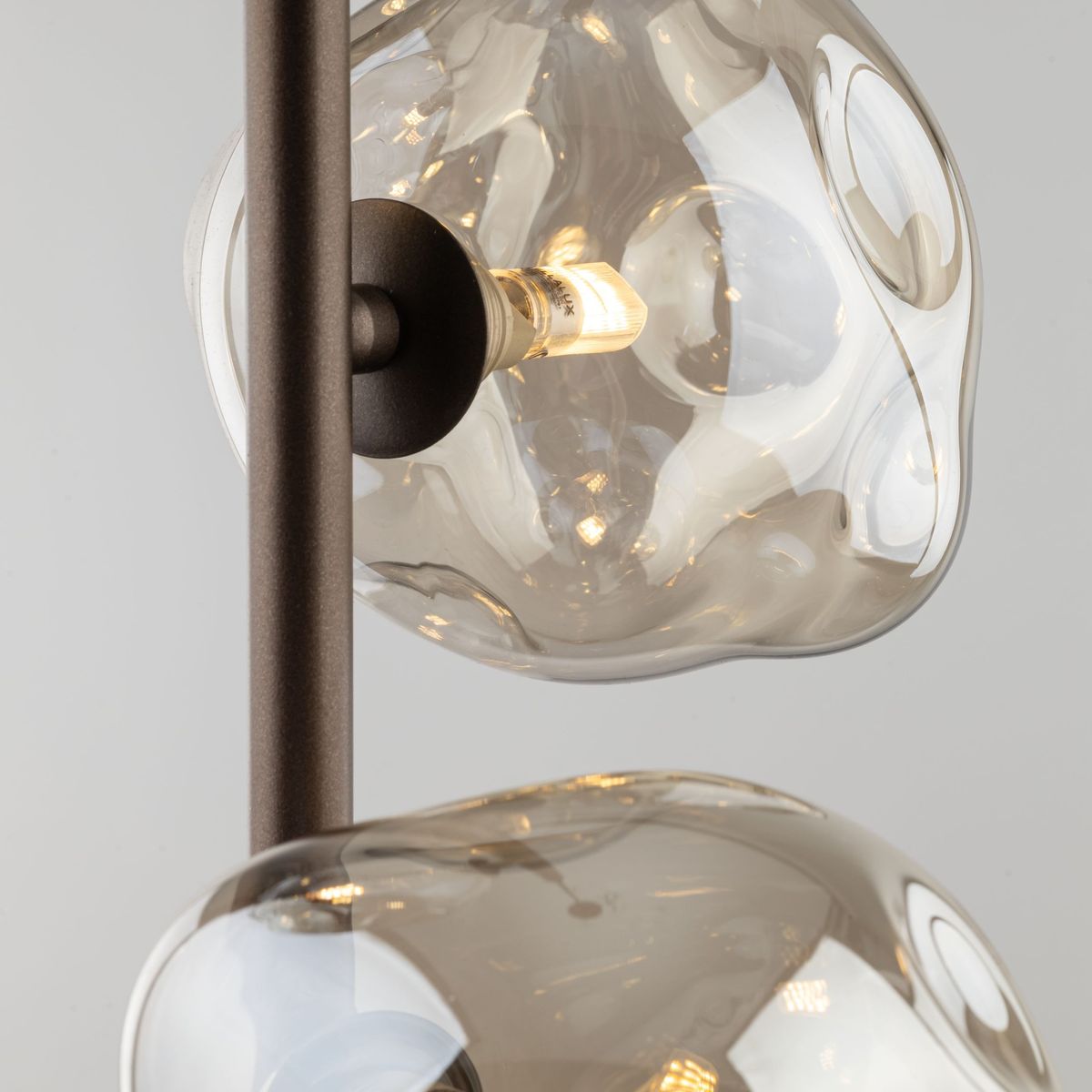 Lava Brown lampa wisząca 3xG9 w brązowym kolorze, z przezroczystymi, szklanymi kloszami o organicznych kształtach. Ujęcie z góry, pokazujące mocowanie i żarówki. Metalowa konstrukcja w kolorze brązowym, eleganckie wykończenie.