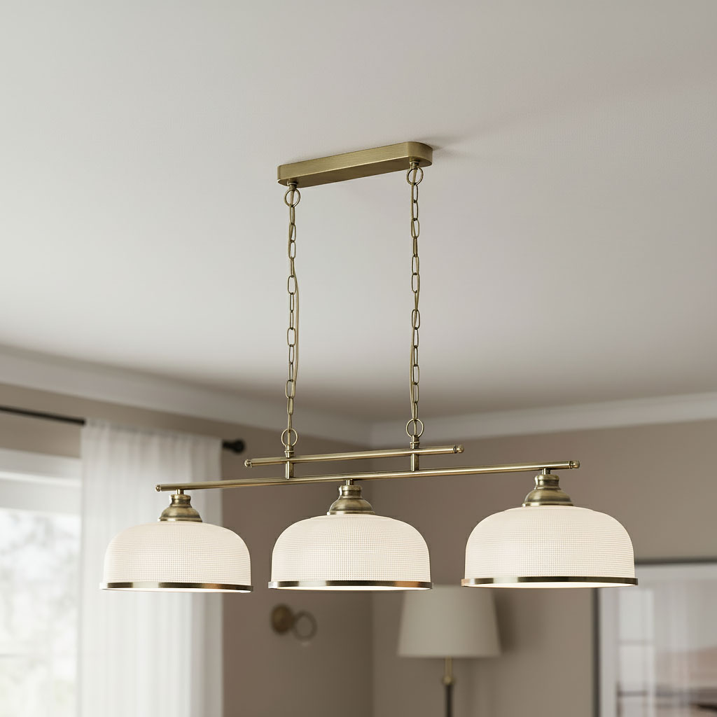 Lampa wisząca Bistro II z trzema okrągłymi kloszami w kolorze antycznego mosiądzu, zawieszona na metalowym stelażu. Klosze mają delikatny wzór i srebrne wykończenie. Zawieszona na łańcuchu, idealna do nowoczesnych wnętrz.