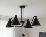 Czarna lampa sufitowa Atlas z czterema kloszami w kształcie stożków, zawieszona na metalowej konstrukcji. Klosze mają białe wnętrza, co zwiększa efekt oświetlenia. Widok z góry, w jasnym wnętrzu z zasłonami.