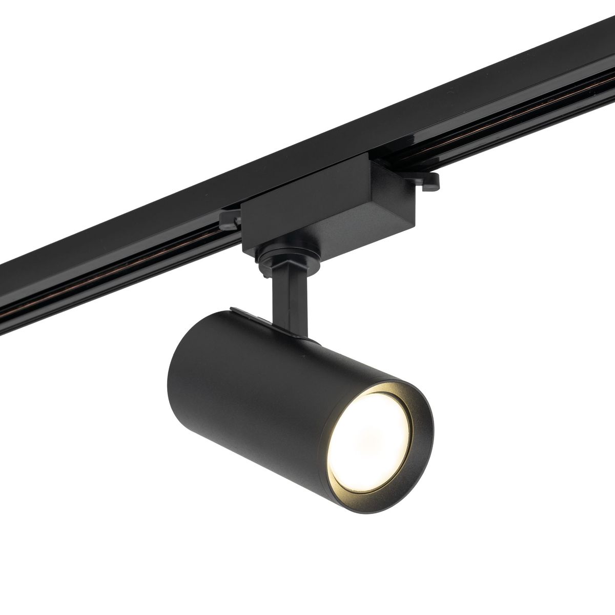 Reflektor spot Tracer 1xGU10 w kolorze czarnym, zamontowany na szynie 1-fazowej. Cylindryczny kształt lampy z widocznym źródłem światła w centralnej części. Ujęcie z boku, pokazujące połączenie z szyną.