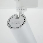 Reflektor Tracer 1xLED 10W CCT w kolorze białym, montowany na szynie 1-fazowej. Widoczna dolna część z otworami wentylacyjnymi oraz oznaczeniami kątów, umożliwiająca regulację kierunku światła. Prosta konstrukcja, minimalistyczny design.