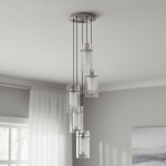 Lampa wisząca Duo I, 5-punktowa, wykonana z srebrnej satyny i przezroczystego szkła. Posiada pięć cylindrycznych kloszy, zawieszonych na cienkich linkach, w eleganckim, nowoczesnym stylu. Ujęcie z góry, na tle jasnego wnętrza.