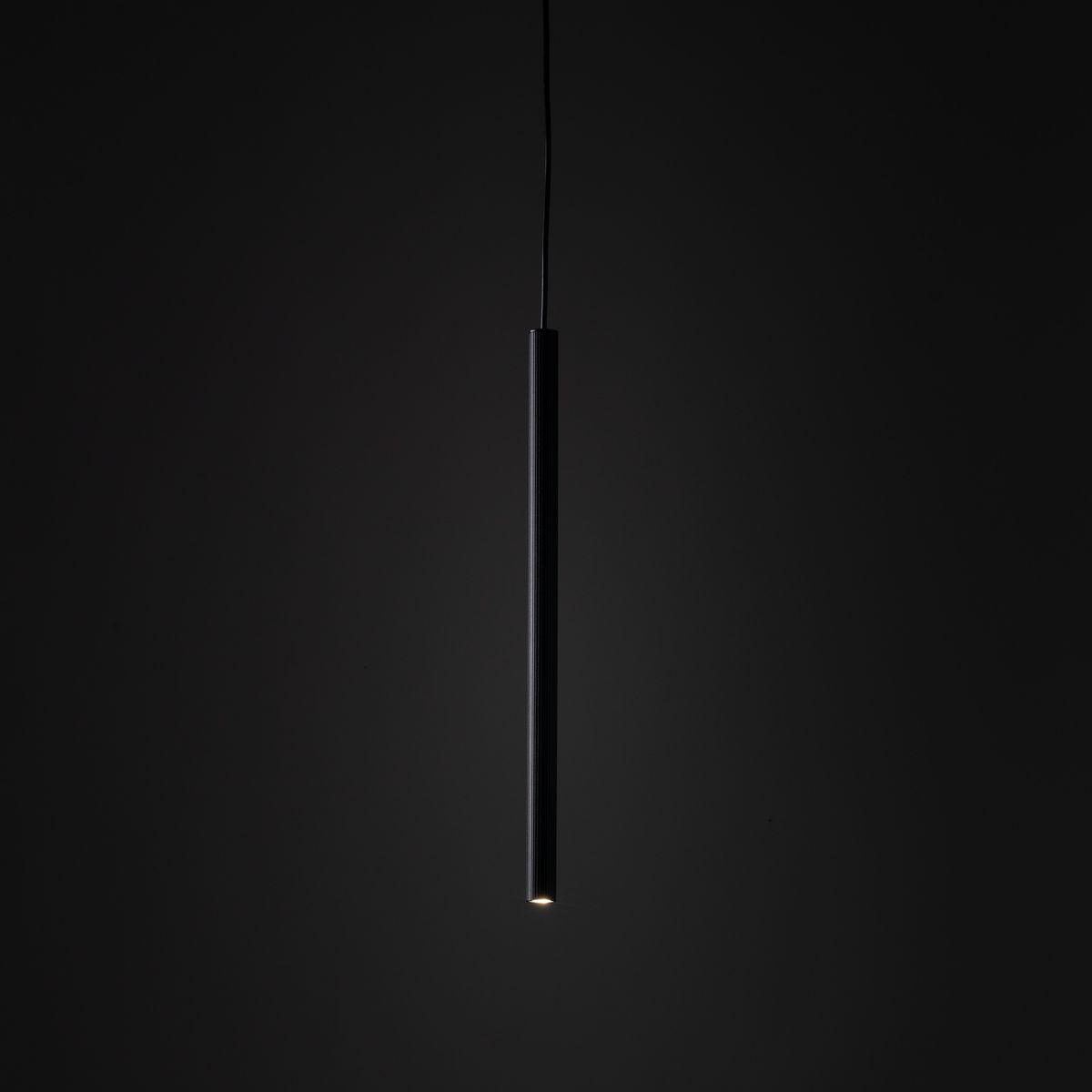 Lampa wisząca Tracer 1xG9 w czarnym kolorze, o prostokątnym kształcie, zawieszona na cienkim przewodzie. Wyposażona w gniazdo G9, umieszczona w centralnej części, na tle ciemnego tła.