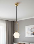 Lampa wisząca Vavil D150 w kolorze złotym i białym z okrągłym kloszem. Ujęcie z dołu, z długim czarnym przewodem, zawieszona pod sufitem w nowoczesnym wnętrzu. Widoczne metalowe detale i gładka, matowa powierzchnia klosza.