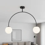 Czarna lampa wisząca Bendo z dwoma okrągłymi kloszami w białym kolorze, zawieszona na łuku z metalowego stelaża. Lampa zamontowana na suficie, w tle widoczny stonowany wystrój wnętrza.