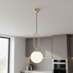 Lampa wisząca Vavil D200 w kolorze złotym i białym, z jedną oprawą. Okrągła, matowa kula zawieszona na cienkim, czarnym przewodzie, z metalową, złotą obudową. Kąt ujęcia frontalny, w minimalistycznym wnętrzu kuchennym.