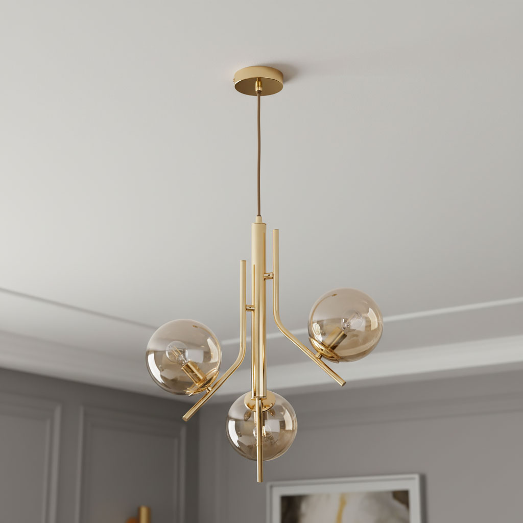 Lampa wisząca Estel 3-punktowa w kolorze złotym, z trzema szklanymi kulami o delikatnym brązowym odcieniu. Produkt zawieszony na cienkim przewodzie, z metalowymi ramionami w nowoczesnym stylu. Idealna do aranżacji wnętrz.