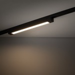 Panel LED Tracer 1x30W w kolorze czarnym, zamontowany na szynie 1-fazowej. Prosty, prostokątny kształt z emitującym światłem paskiem na górze, widoczny na tle szarej ściany.