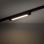 Czarny panel LED 20W zamontowany na szynie 1-fazowej, o prostokątnym kształcie. Oświetlenie emituje jasne światło, umieszczone w kącie pod sufitem. Tło ciemne, co podkreśla design produktu.