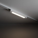 Panel LED Tracer 1xLED 20W w kolorze białym, zamontowany na szynie 1-fazowej. Prosty, prostokątny kształt z emitującym światłem odcieniem białym, umieszczony pod kątem na tle ciemnej ściany.