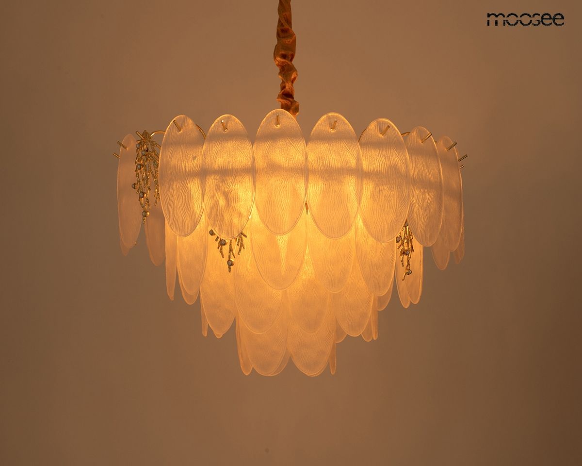 Lampa wisząca Klara 80, złota, o 15 oprawkach E14. Wykonana z przezroczystego tworzywa, z dekoracyjnymi elementami w postaci małych zawieszek. Ujęcie z góry, pokazujące detal i emitujące ciepłe światło.