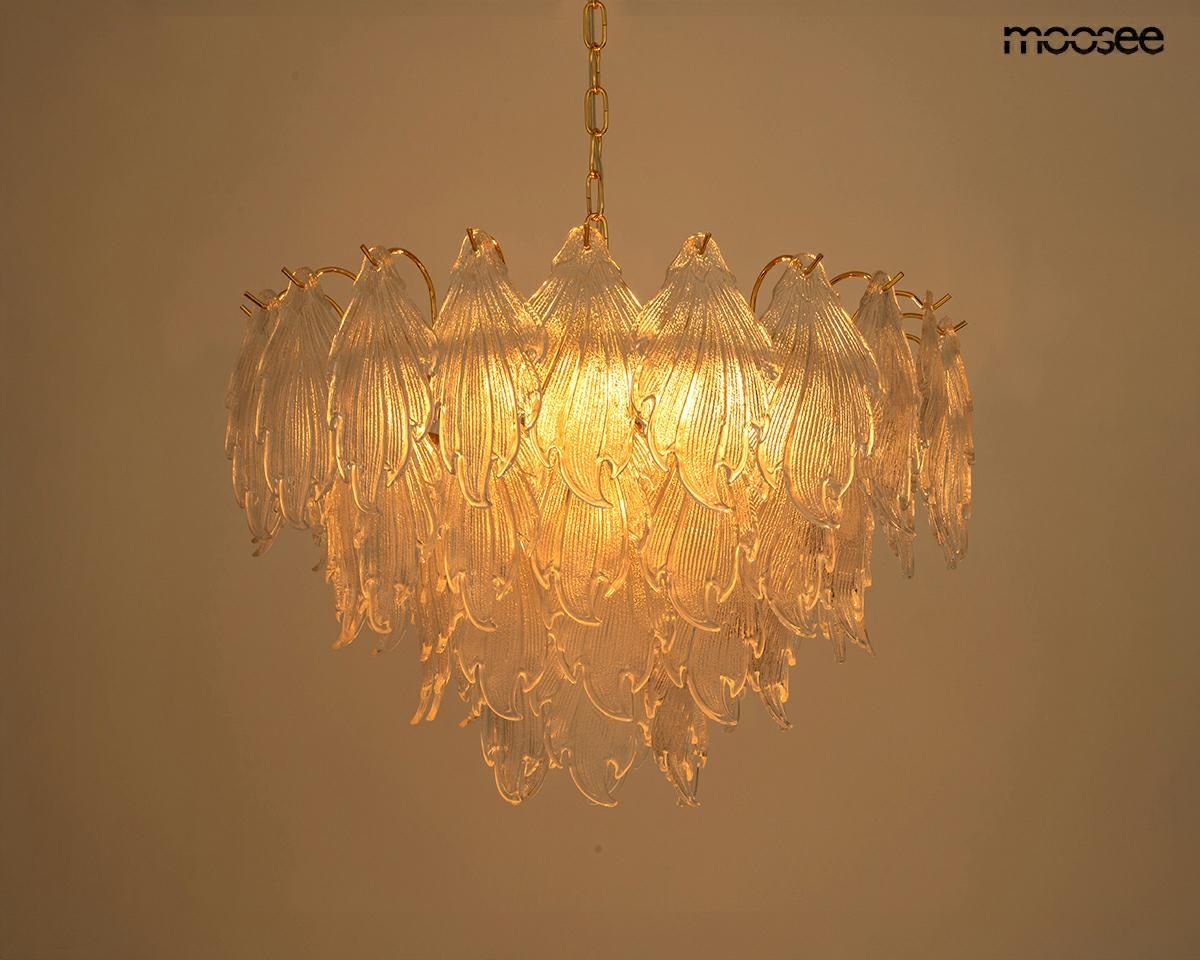 Lampa wisząca Scarlett 80, złota, z 15 miejscami na żarówki E14. Ozdobna, z przezroczystymi, falistymi kloszami przypominającymi liście, zawieszona na złotym łańcuchu. Świeci ciepłym światłem, idealna do eleganckich wnętrz.