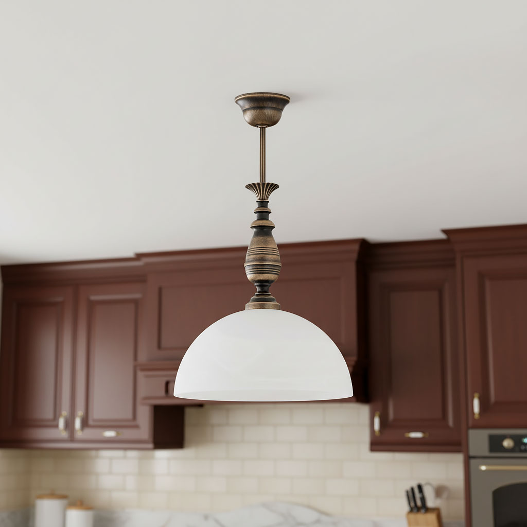 Lampa wisząca Felix D30 w kolorze patyny z białym kloszem, zawieszona na cienkim metalowym przewodzie. Kształt klosza półkulisty, z dekoracyjną podstawą. W tle widoczne ciemne meble kuchenne.