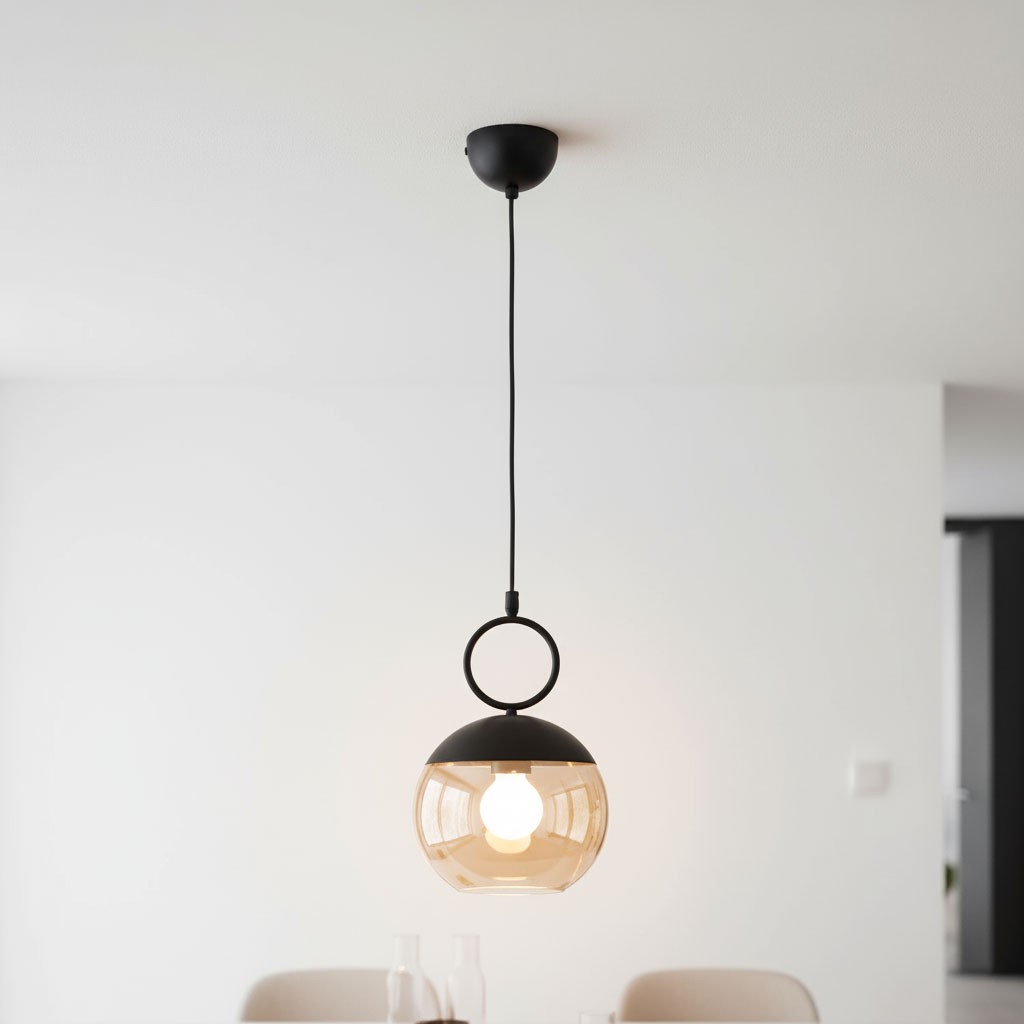 Lampa wisząca Sitro 20 w kolorze czarnym z bursztynowym kloszem, zawieszona na czarnym przewodzie. Okrągły metalowy uchwyt u góry. Źródło światła E27 widoczne wewnątrz klosza. Prosta, nowoczesna forma, idealna do wnętrz.