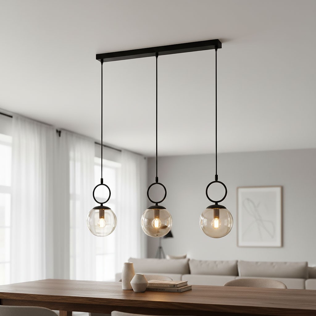 Lampa wisząca Sitro, czarna, z trzema szklanymi kloszami w odcieniu bursztynowym. Ułożona poziomo, zawieszona na prostokątnej listwie, z metalowymi pierścieniami. Widoczna w nowoczesnym wnętrzu nad drewnianym stołem.