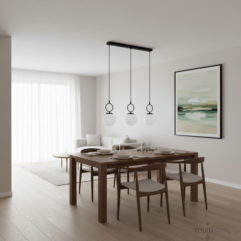 Lampa wisząca Sitro z trzema kulistymi kloszami w białym kolorze, zawieszona na czarnej listwie. Ułożona nad drewnianym stołem w nowoczesnym wnętrzu, z jasnym tłem i naturalnym światłem.