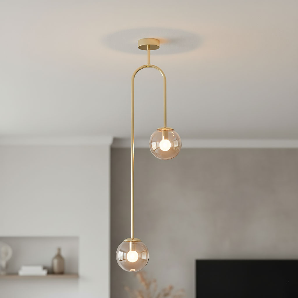 Lampa wisząca Vector 2xE14 w kolorze złotym z bursztynowymi kloszami. Posiada dwa okrągłe, przezroczyste klosze zawieszone na cienkim, złotym stelażu. Ujęcie z góry, zawieszona pod sufitem w nowoczesnym wnętrzu.