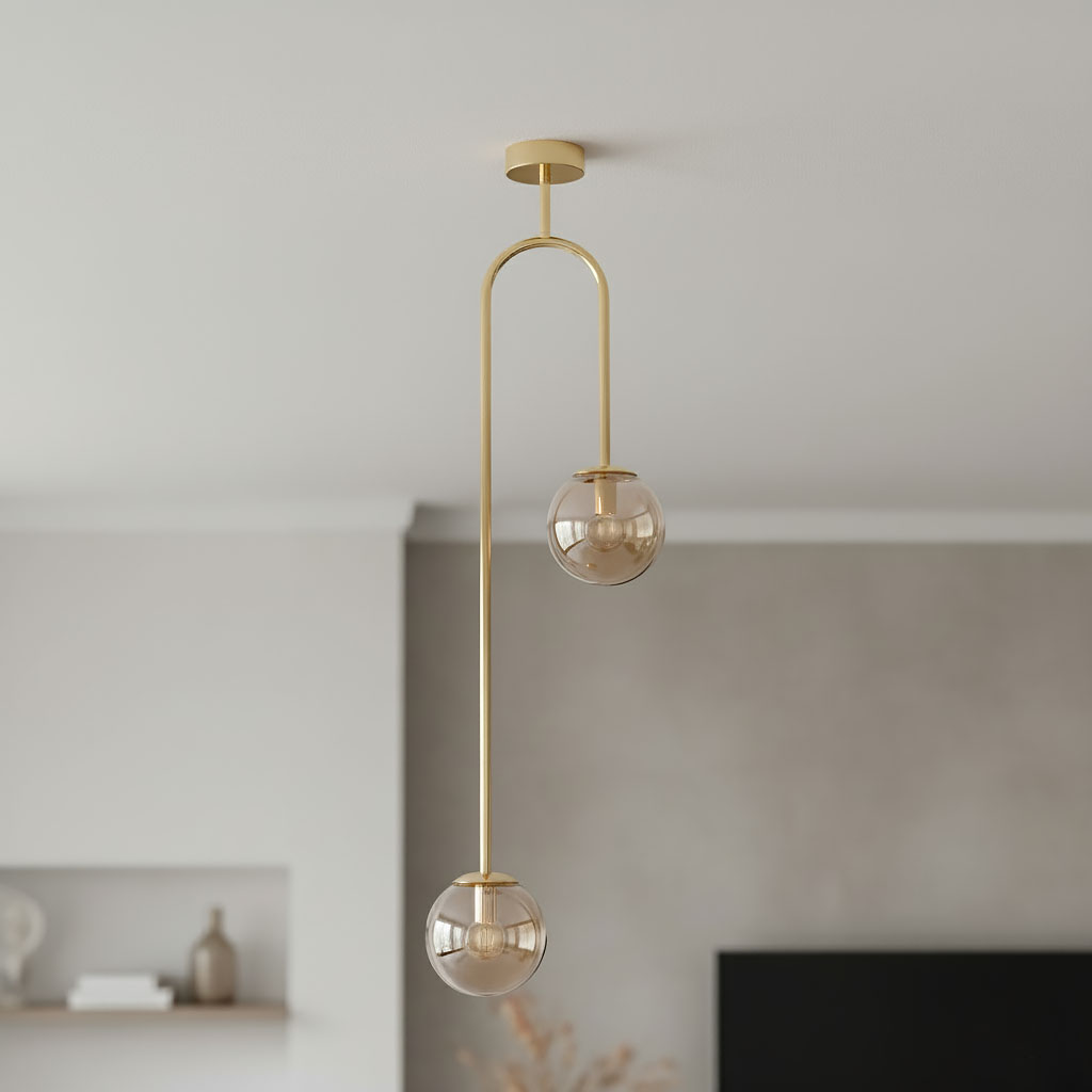 Lampa wisząca Vector w kolorze złotym z dwoma kulistymi kloszami w bursztynowym odcieniu. Posiada podwójny, asymetryczny uchwyt, wisi z sufitu w nowoczesnym wnętrzu. Klosze z przezroczystego szkła, metalowa konstrukcja.