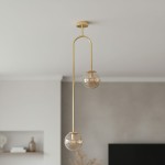 Lampa wisząca Vector w kolorze złotym z dwoma kulistymi kloszami w bursztynowym odcieniu. Posiada podwójny, asymetryczny uchwyt, wisi z sufitu w nowoczesnym wnętrzu. Klosze z przezroczystego szkła, metalowa konstrukcja.