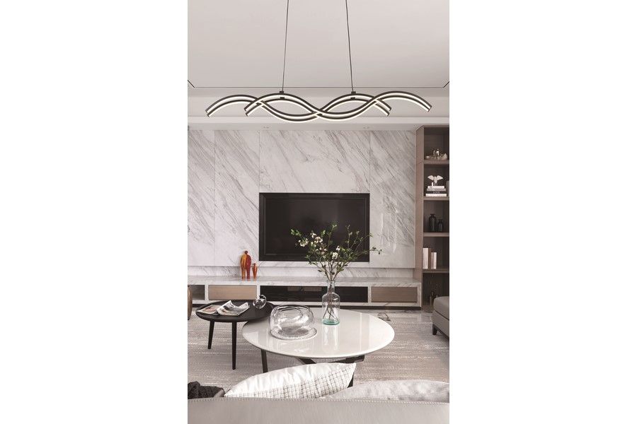 Lampa wisząca LED Aruba 40W CCT w kolorze czarnym, w kształcie fal, zawieszona nad okrągłym stołem. W tle widoczna telewizor na ścianie z marmurowym wykończeniem oraz dekoracyjna roślina w wazonie.