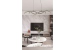 Lampa wisząca LED Aruba 40W CCT w kolorze czarnym, w kształcie fal, zawieszona nad okrągłym stołem. W tle widoczna telewizor na ścianie z marmurowym wykończeniem oraz dekoracyjna roślina w wazonie.