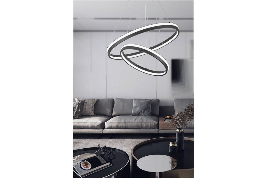 Proxima lampa wisząca LED 40W + 24W CCT w kolorze czarnym, z podwójnym okręgiem, zawieszona nad elegancką kanapą w nowoczesnym wnętrzu. Lampa ma minimalistyczny design, z wyraźnym oświetleniem LED, idealna do salonu.