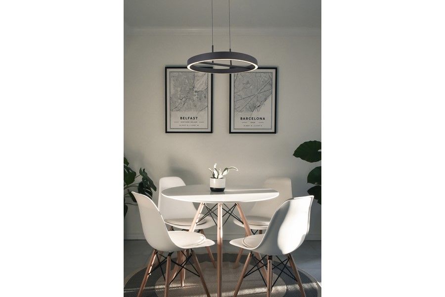 Lampa wisząca LED Coltrain 32W CCT w kolorze czarnym, zamontowana nad okrągłym białym stołem. W tle widoczne dwa obrazy oraz roślinność. Prosta, nowoczesna forma o okrągłym kształcie, zawieszona na dwóch linkach.