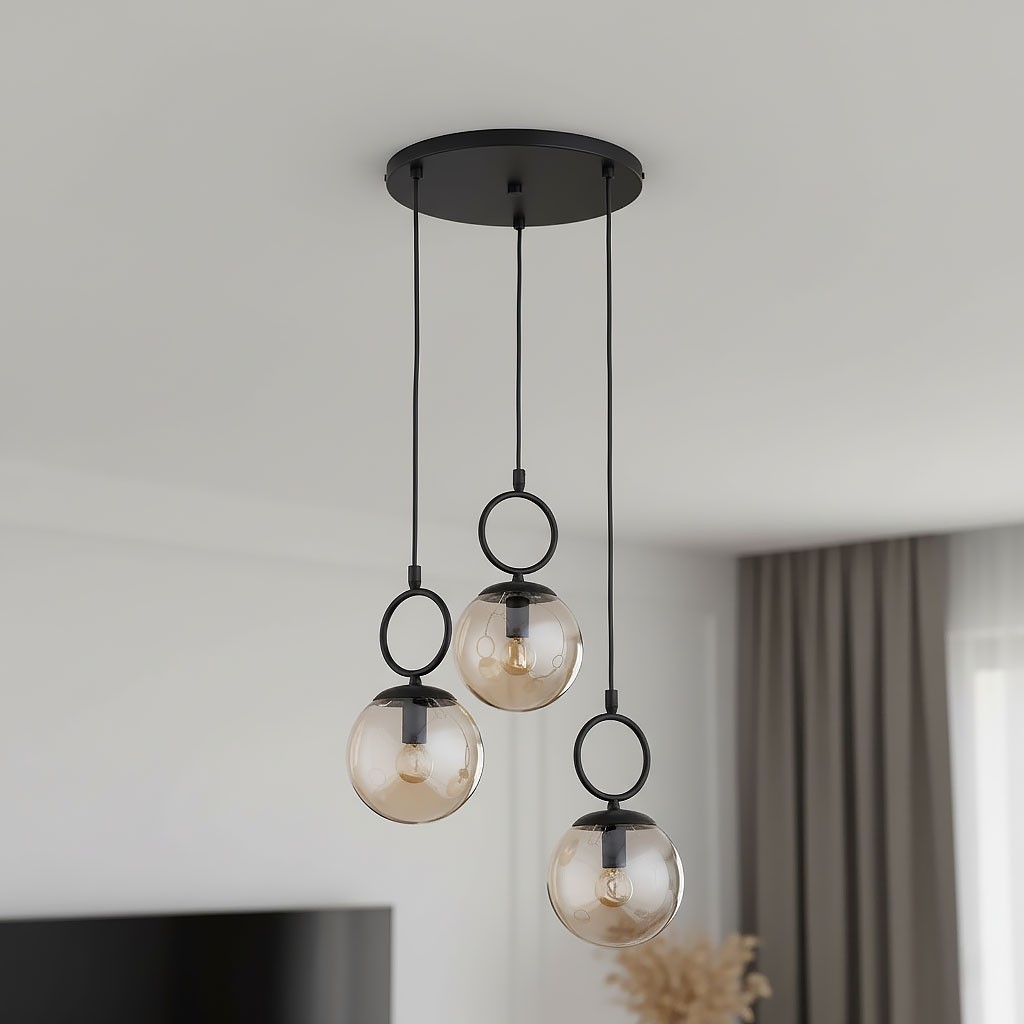 Lampa wisząca Sitro z trzema kloszami w kształcie kul, wykonana z bursztynowego szkła, zawieszona na czarnych linkach. Elementy mocujące w kolorze czarnym, klasyczny design, idealna do nowoczesnych wnętrz.