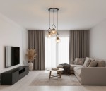 Lampa wisząca Sitro z trzema żarówkami E14 w kolorze czarnym i bursztynowym, zawieszona na cienkich linkach. Okrągłe klosze z bursztynowego szkła, umieszczone w różnych wysokościach, w nowoczesnym wnętrzu z szaro-beżowymi tonami.