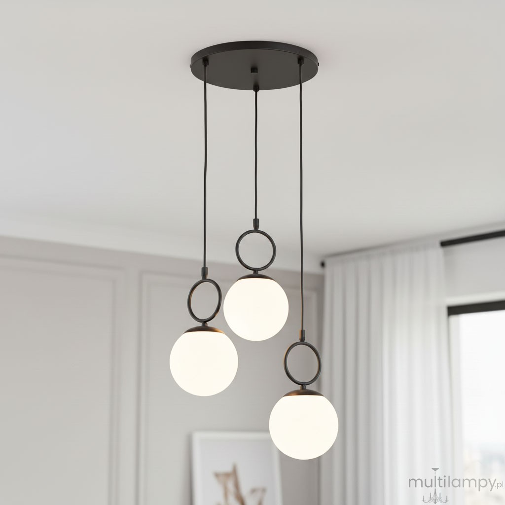 Lampa wisząca Sitro z trzema kulistymi kloszami w białym kolorze, zawieszona na czarnych linkach, z okrągłymi elementami mocującymi. Zainstalowana na sufitowej podstawie w kolorze czarnym, w minimalistycznym wnętrzu.
