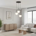 Lampa wisząca Sitro 3xE14 w kolorze czarnym z białymi kulami. Zawieszona na trzech cienkich linkach, umieszczona w nowoczesnym wnętrzu z jasnymi ścianami, drewnianym meblem i rośliną w tle.