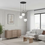 Lampa wisząca Sitro 3xE14 w kolorze czarnym i białym z trzema okrągłymi kloszami zawieszonymi na cienkich linkach. Umieszczona na prostokątnej podstawie sufitowej, w nowoczesnym wnętrzu z jasnymi ścianami i drewnianymi meblami.