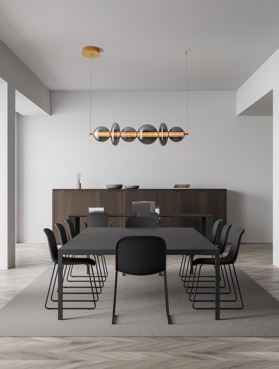 Lampa wisząca Morros 1xLED 29W w kolorze złotym, zawieszona nad czarnym stołem w nowoczesnej jadalni. Kształt lampy to podłużny element z przezroczystymi kloszami, tworzącymi elegancki efekt świetlny. Świetna do aranżacji wnętrz.