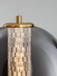 Lampa wisząca Morros z złotym metalowym kloszem i przezroczystymi akcentami, zawieszona na białym przewodzie. Źródło światła LED 8W umieszczone w dekoracyjnym, kaskadowym przegrodzie. Tło szare, minimalistyczne.