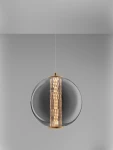Lampa wisząca Morros z pojedynczym źródłem światła LED 8W, złota. Okrągła, szklana konstrukcja z centralnym, teksturowanym elementem, zawieszona na cienkim przewodzie, na jednolitym tle.