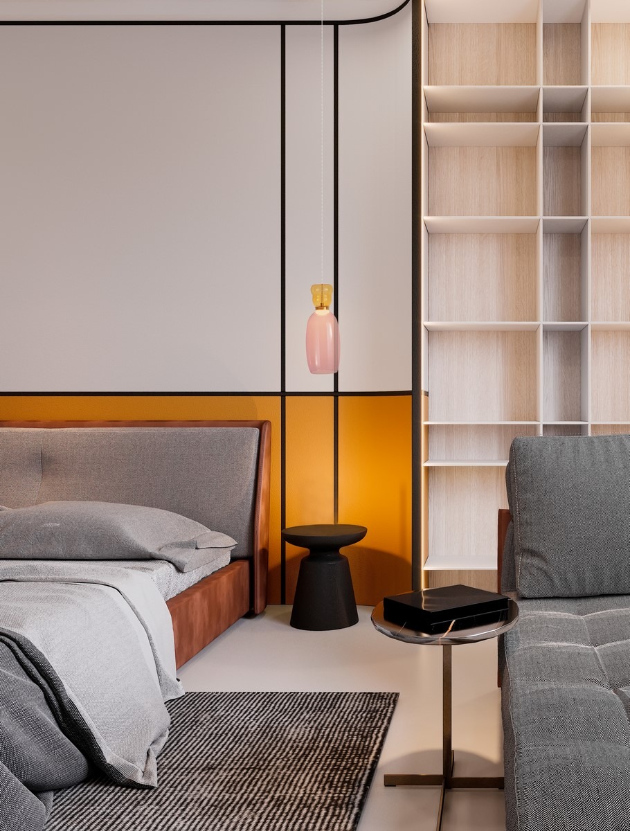 Lampa wisząca Perene z różowym kloszem i złotym detalem, zawieszona nad łóżkiem w nowoczesnym wnętrzu. Kształt owalny, materiał szklany, z widocznym przewodem. Tło w odcieniach bieli i pomarańczy, z minimalistycznym meblem obok.