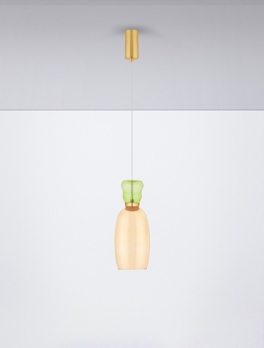 Lampa wisząca Perene z pojedynczym źródłem światła LED 9W. Szklany klosz w odcieniu złotej żółci z zielonym detalem na górze. Zawieszona na cienkim przewodzie, montowana do sufitu. Proste tło w jasnych kolorach.