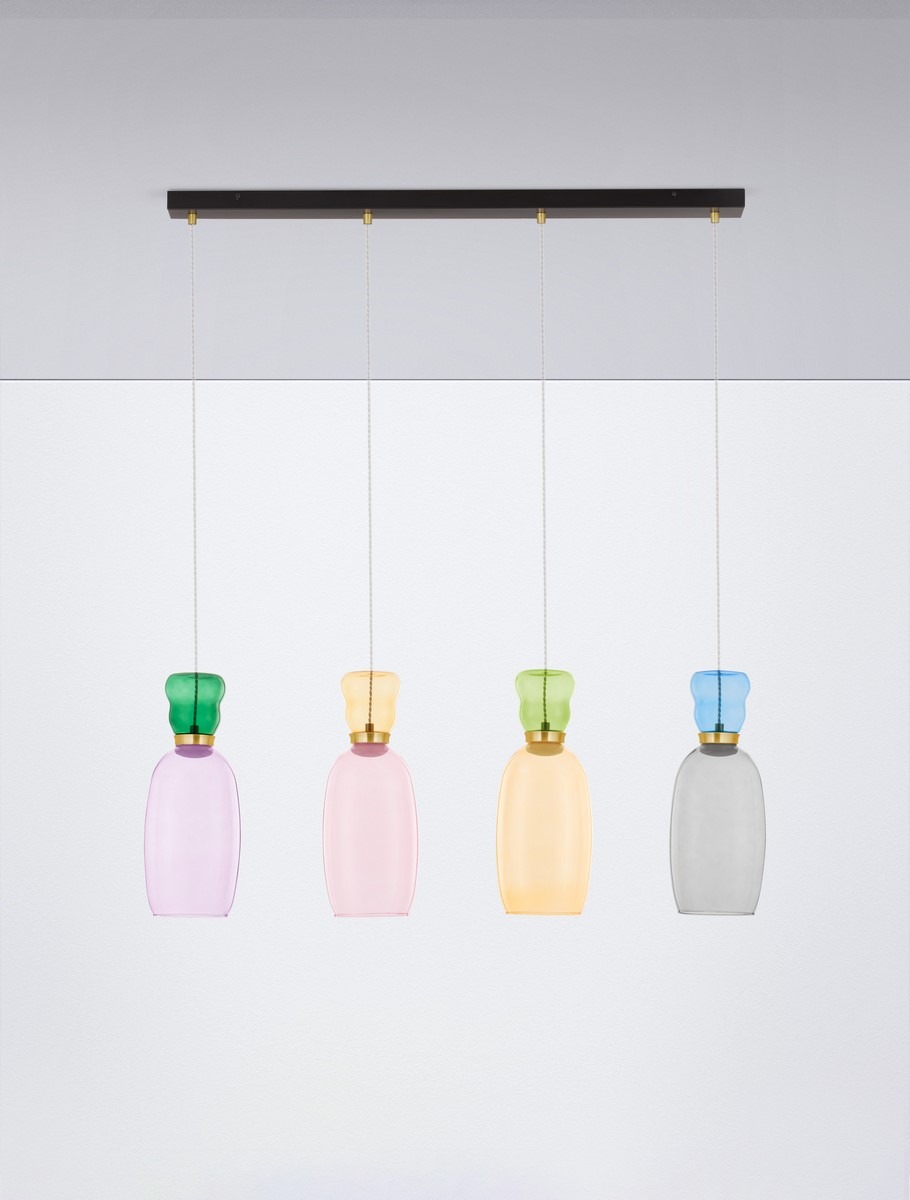 Lampa wisząca Perene z czterema kloszami LED w kolorach: fioletowym, różowym, żółtym i szarym, zawieszona na czarnej listwie. Klosze mają zaokrąglone kształty i ozdobne, kolorowe uchwyty. Lampa wisi na cienkich linkach w prostym otoczeniu.