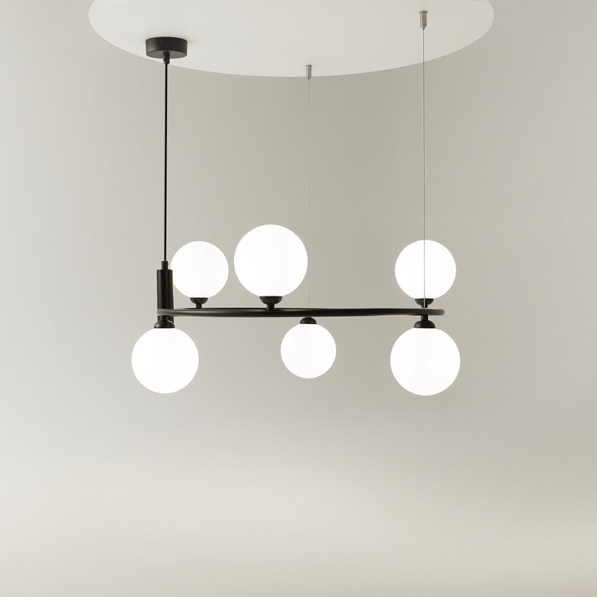 Lampa wisząca Ring 6-punktowa w kolorze czarnym, z sześcioma okrągłymi, białymi kloszami, zawieszona na cienkich linkach. Kształt minimalistyczny, umiejscowiona centralnie, z prostokątnym sufitem w tle.