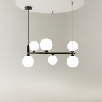 Lampa wisząca Ring 6-punktowa w kolorze czarnym, z sześcioma okrągłymi, białymi kloszami, zawieszona na cienkich linkach. Kształt minimalistyczny, umiejscowiona centralnie, z prostokątnym sufitem w tle.